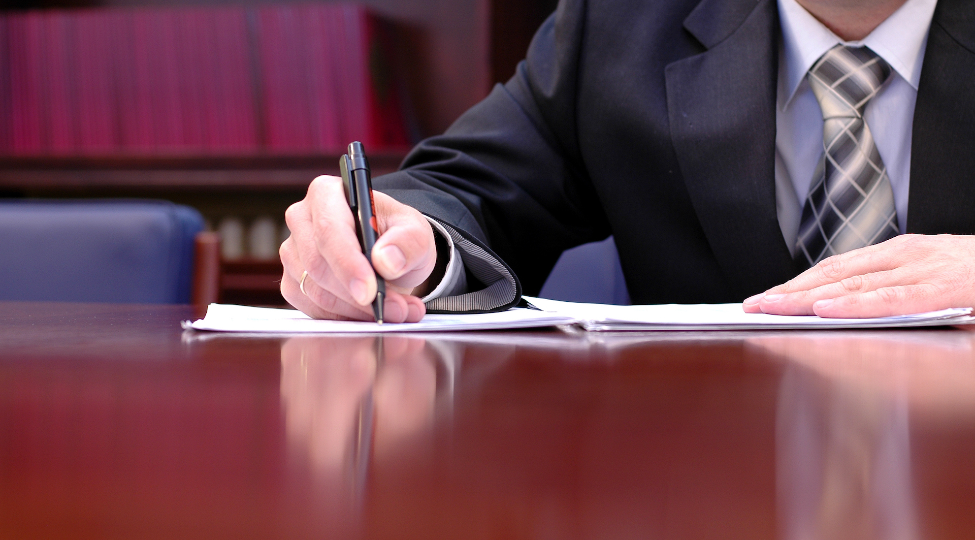 Person in Suit and Tie Signing Contract