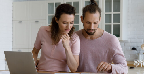 Couple Reviewing Bills at Kitchen Counter